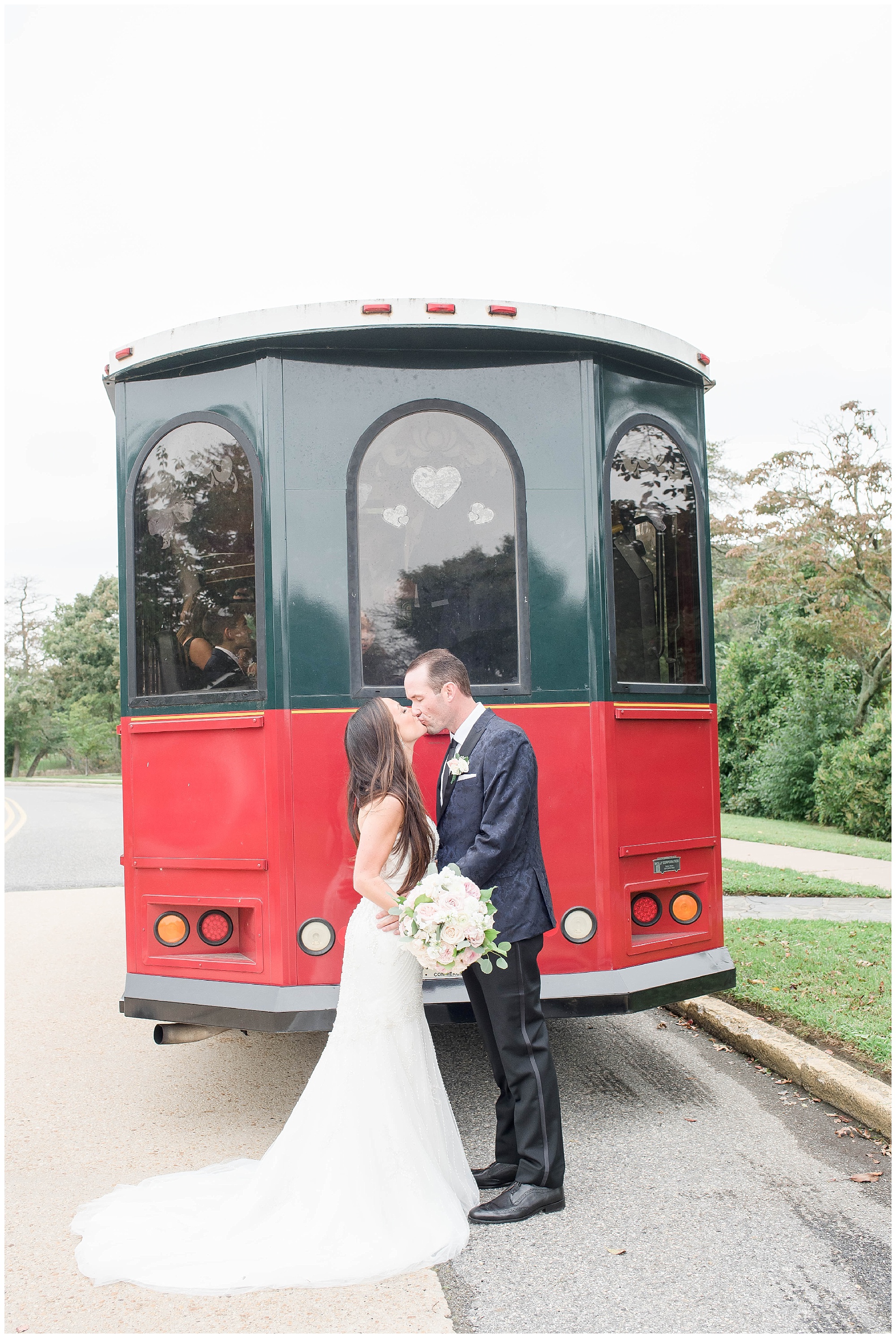 bride and groom kissing in front of trolley