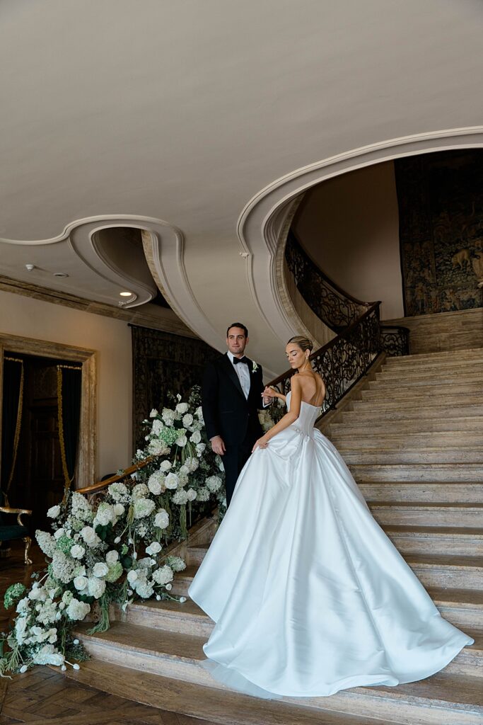 bride in silk kleinfelds dress on staircase