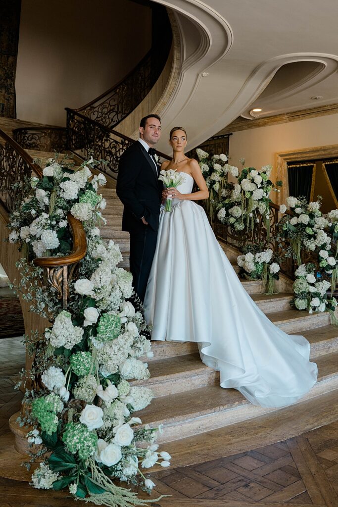 bride and groom portraits on staircase with flowers on wedding day