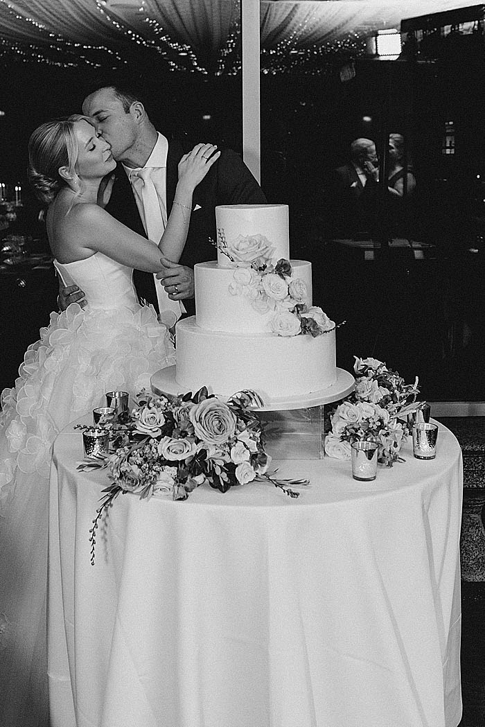 bride and groom kiss and cut wedding cake